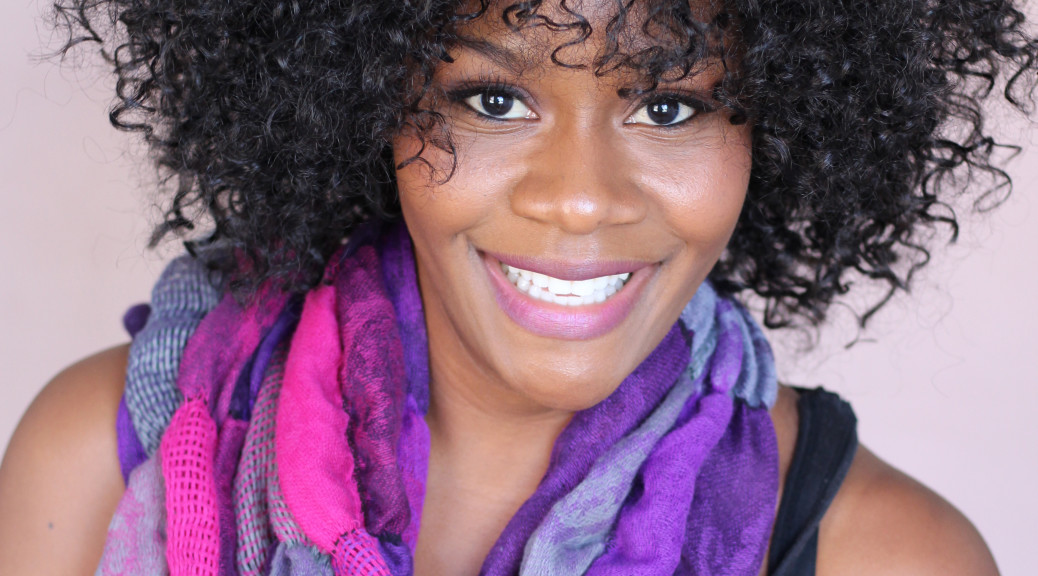 Headshot of actress Brandy in a purple and pink scarf